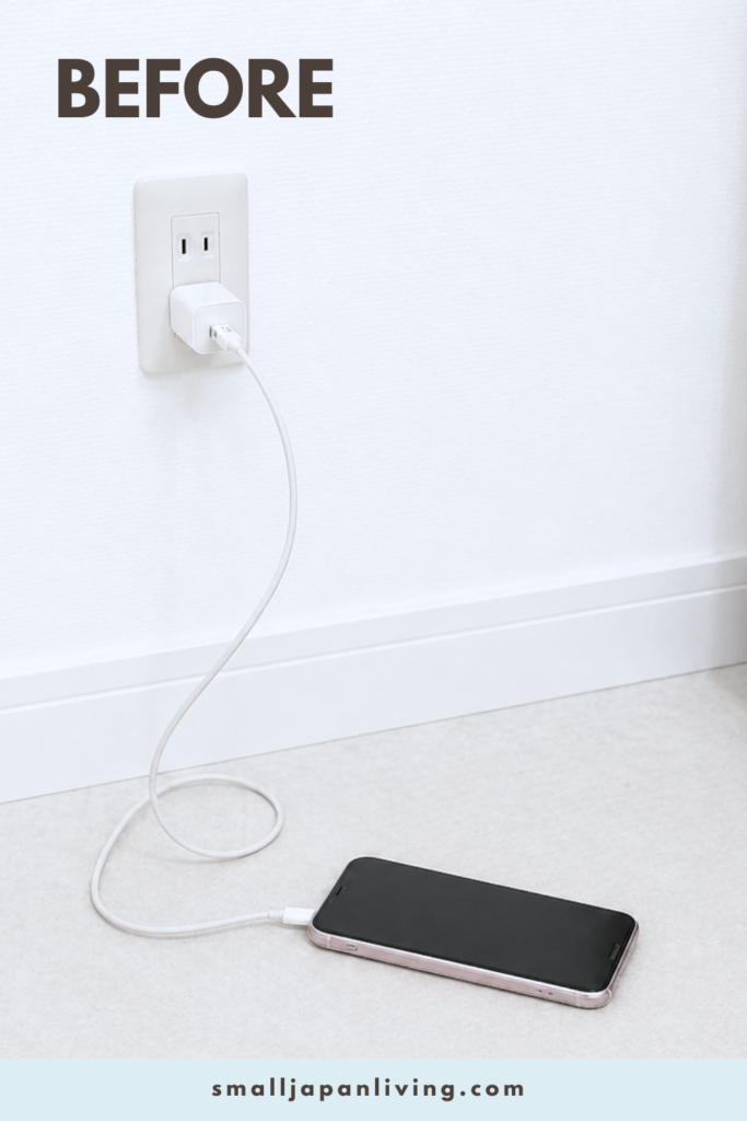 Cluttered phone charging cables on the floor near an outlet in a small apartment, showing a messy and unorganized charging area before a space-saving hack